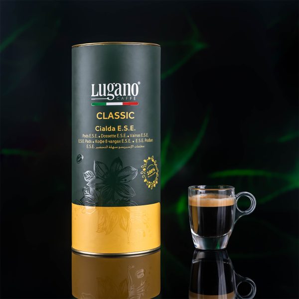 Lugano Caffè Classic Espresso Pod 18 pcs cylinder pack and a cup in a studio set